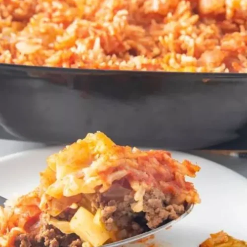 A fusion of flavors awaits as tender cabbage leaves embrace a savory blend of seasoned ground meat, aromatic onions, and fragrant rice, all topped with a luscious tomato sauce.