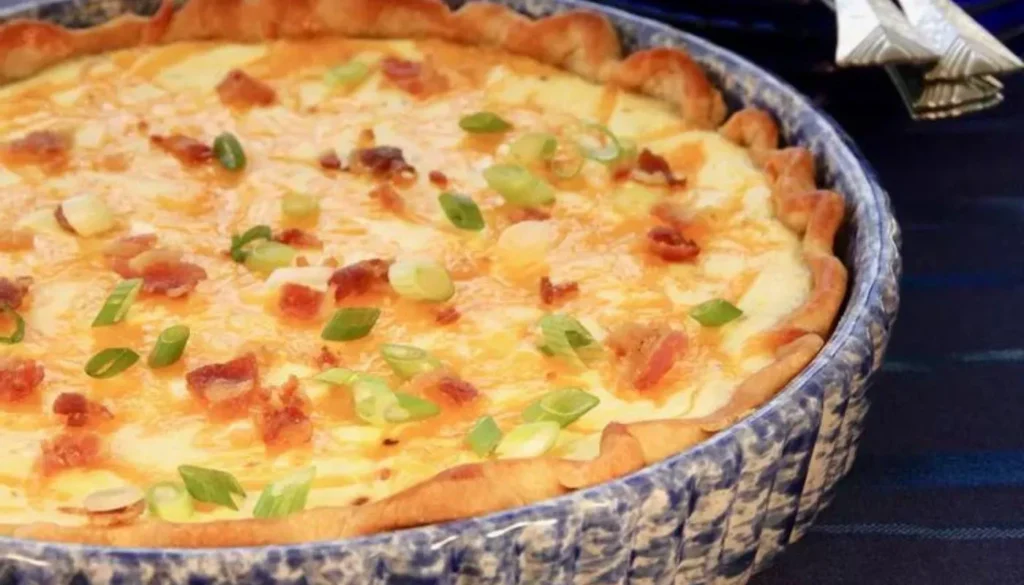 This savory dish features a golden, flaky crust filled with creamy cheddar cheese, crispy bacon, and perfectly caramelized onions.