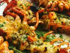 Indulge in the exquisite flavors of Lobster Thermidor, a classic French dish featuring succulent lobster bathed in a creamy, savory sauce and topped with a gratifying layer of cheese.