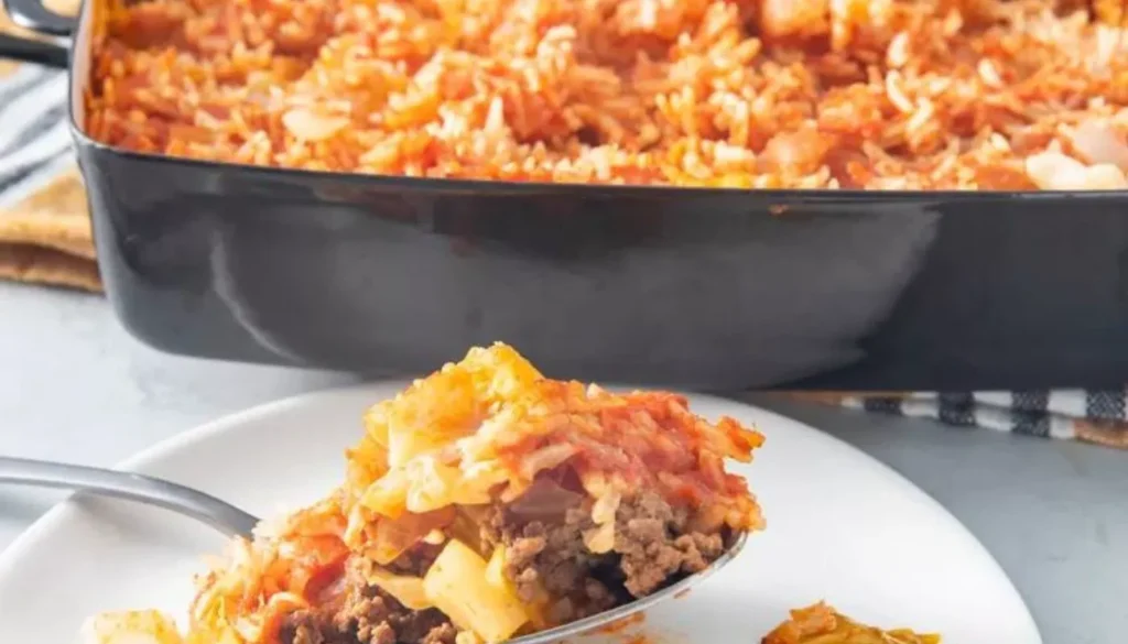 A fusion of flavors awaits as tender cabbage leaves embrace a savory blend of seasoned ground meat, aromatic onions, and fragrant rice, all topped with a luscious tomato sauce.