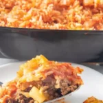 A fusion of flavors awaits as tender cabbage leaves embrace a savory blend of seasoned ground meat, aromatic onions, and fragrant rice, all topped with a luscious tomato sauce.