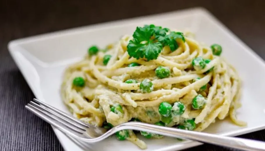 This mouthwatering recipe combines perfectly cooked linguine with a rich and creamy pesto sauce, all adorned with a generous sprinkle of gooey cheese and a burst of vibrant peas.