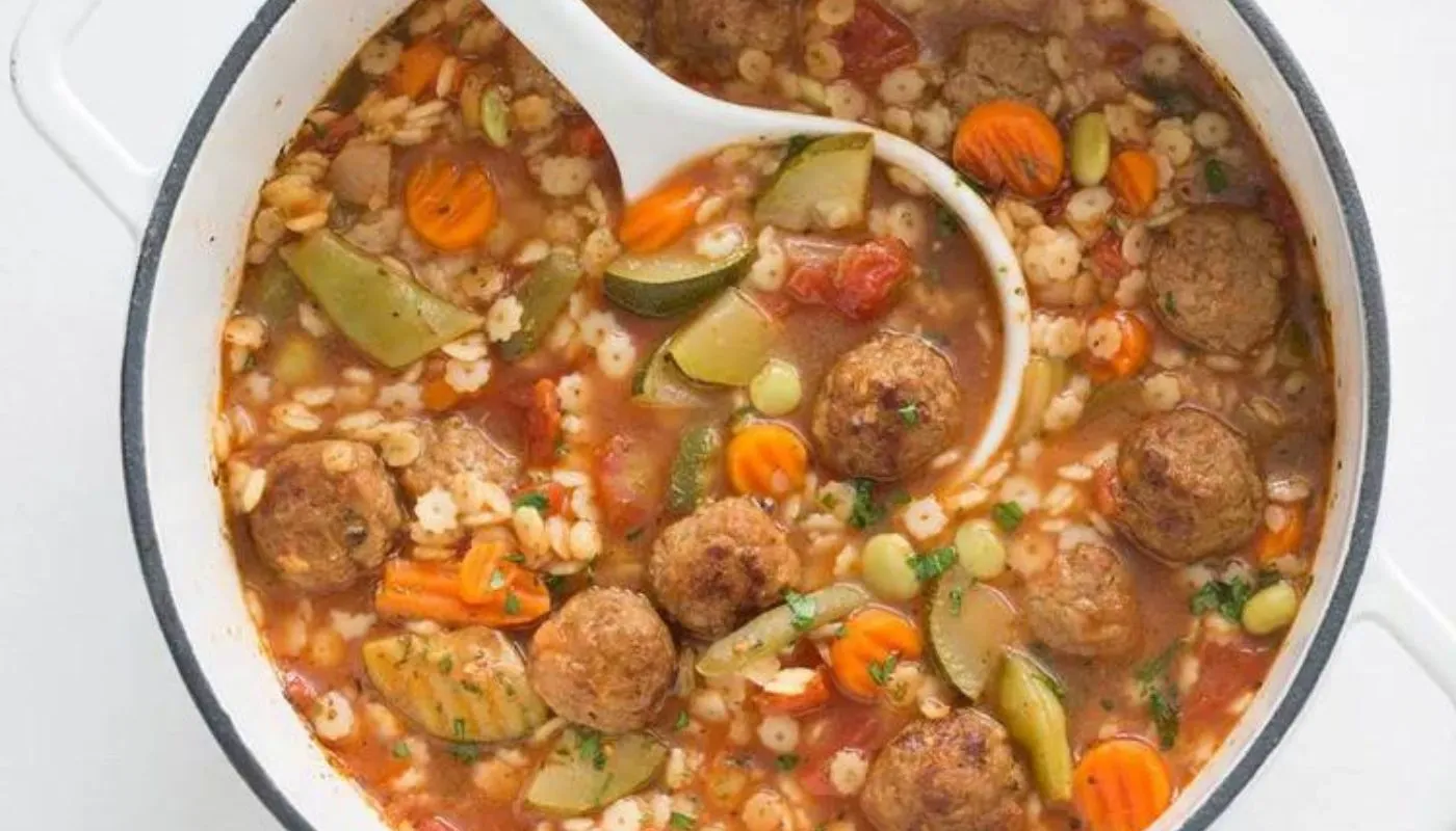 Savory, succulent meatballs infused with aromatic herbs and spices swim in a rich, tomato-based broth.