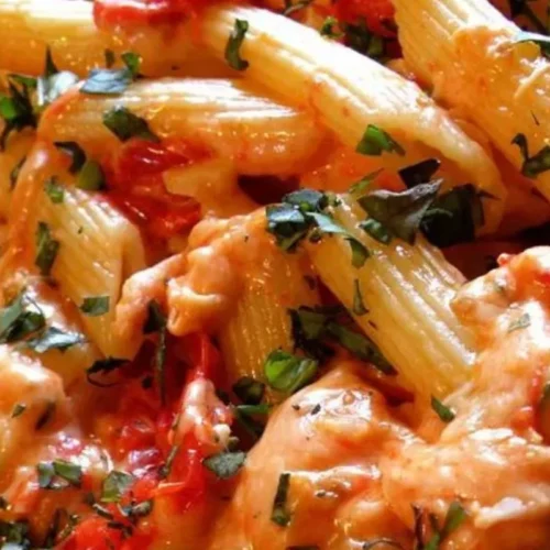 This mouthwatering recipe features al dente penne pasta smothered in a rich tomato and basil sauce, topped with a generous sprinkle of melted, gooey Parmesan cheese.