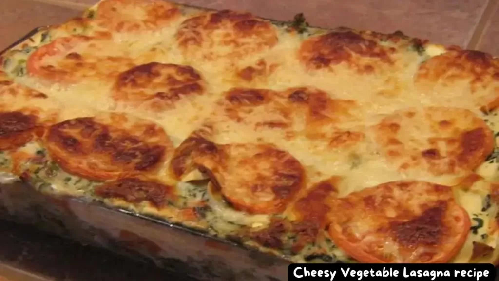 A golden-baked cheesy vegetable lasagna in a casserole dish, topped with melted cheese and crispy edges.