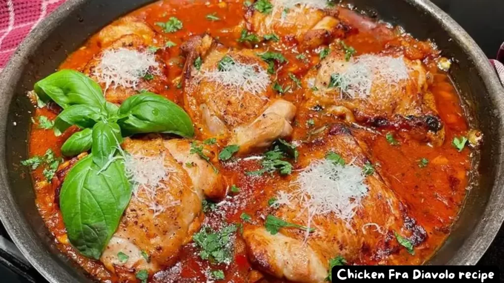 A skillet of Chicken Fra Diavolo garnished with fresh basil and Parmesan cheese.