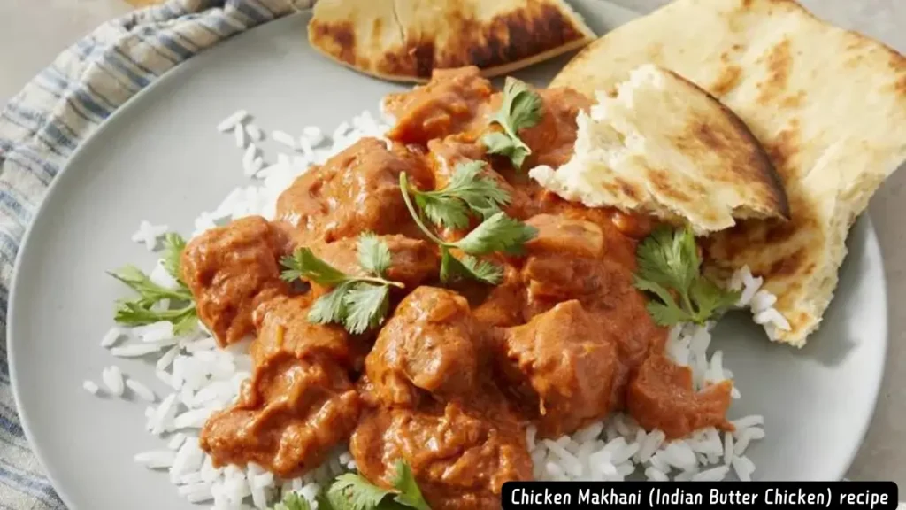 A plate of Chicken Makhani, also known as Indian Butter Chicken, garnished with cilantro and served with basmati rice and naan bread.