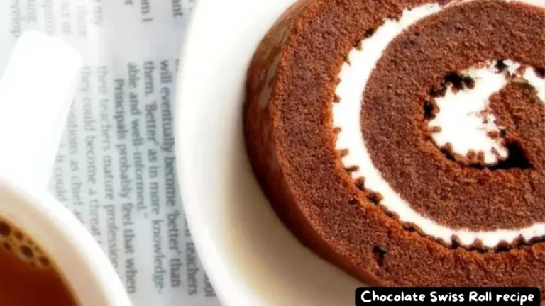 A close-up view of a slice of Chocolate Swiss Roll served on a white plate.