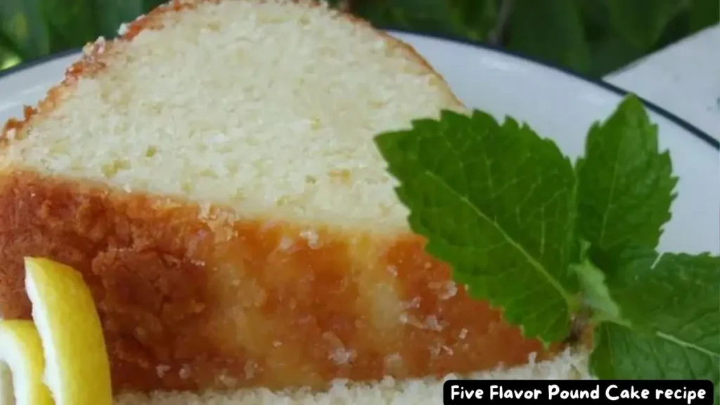 A slice of Five Flavor Pound Cake garnished with a fresh mint leaf and a lemon twist.