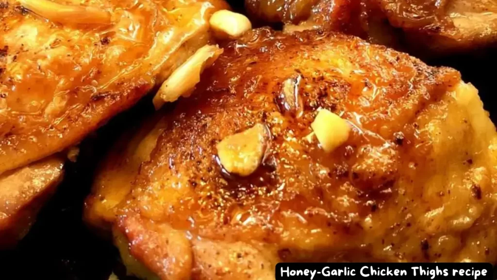 Close-up of Honey-Garlic Chicken Thighs garnished with garlic and cooked to a golden brown.