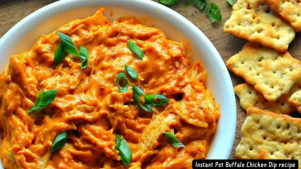 A bowl of creamy, spicy Instant Pot Buffalo Chicken Dip garnished with green onions and served with crackers.