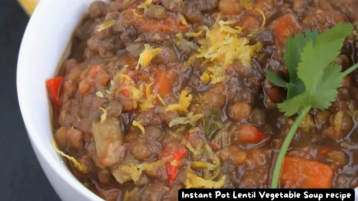 A close-up of a bowl of Instant Pot Lentil Vegetable Soup garnished with lemon zest and parsley.