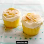 A batch of freshly baked lemon cupcakes topped with lemon cream icing.