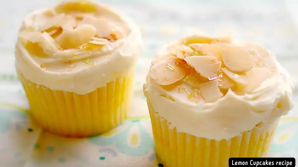 Two lemon cupcakes topped with creamy icing and garnished with almond slices.