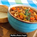 A bowl of Meme's Pasta Fagioli with ditalini pasta, cannellini beans, ground beef, and vegetables