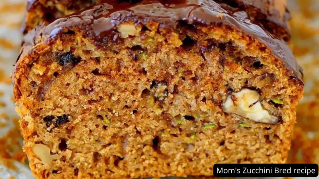 Close-up of a sliced loaf of Mom's Zucchini Bread, showcasing its moist texture and studded with walnuts and chocolate chips.