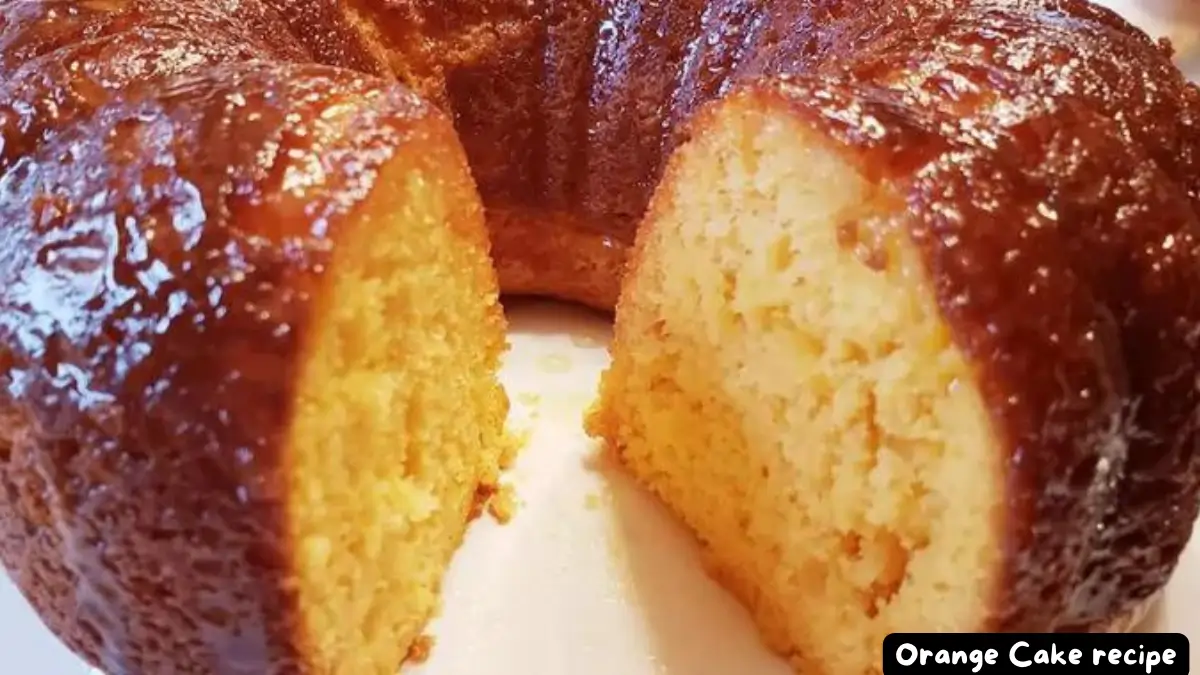 A close-up view of a moist and flavorful orange Bundt cake, showing its golden interior and shiny glaze.