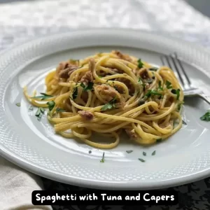 A plate of spaghetti with tuna and capers garnished with fresh parsley.