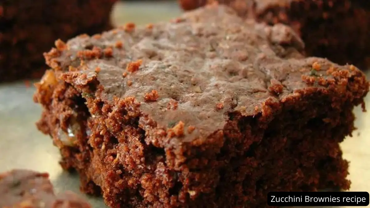 A close-up of a deliciously moist zucchini brownie with a rich chocolate frosting, showcasing its fudgy texture and decadent appearance.