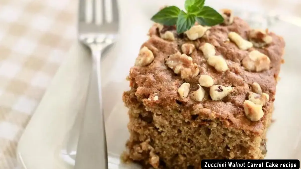 Slice of delicious zucchini walnut carrot cake topped with walnuts and a mint leaf