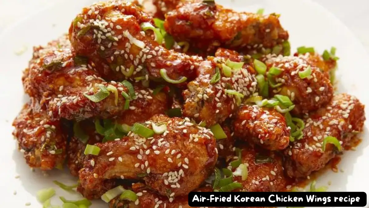 Plate of air-fried Korean chicken wings garnished with sesame seeds and chopped green onions.