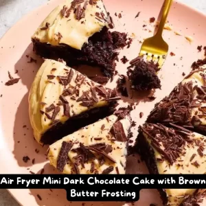 A slice of air fryer mini dark chocolate cake topped with rich brown butter frosting and garnished with dark chocolate shavings.