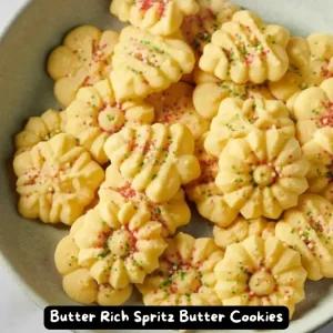 A plate of colorful Butter Rich Spritz Butter Cookies decorated with sprinkles and sugar.