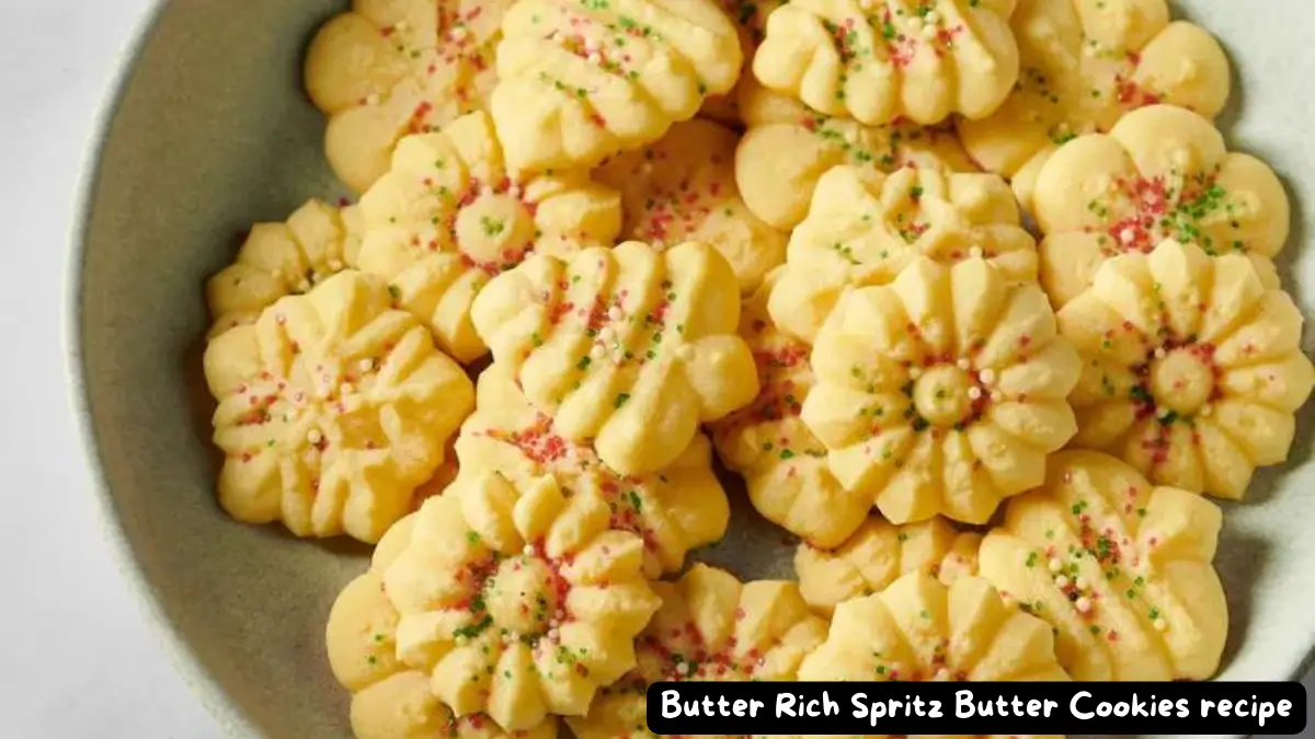 A plate filled with beautifully shaped Butter Rich Spritz Butter Cookies, garnished with colorful sprinkles.