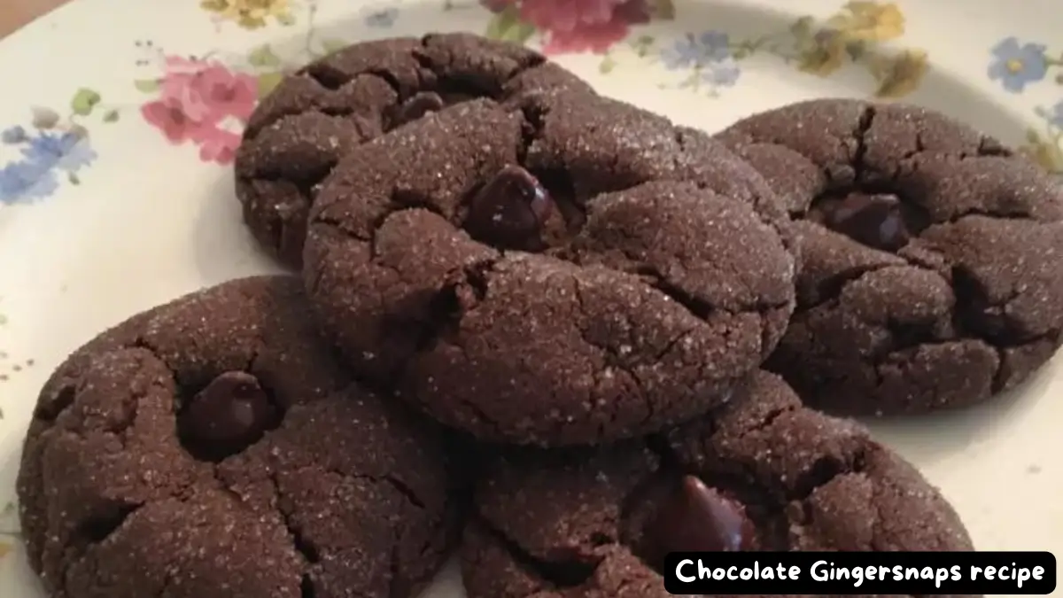 Close-up of chocolate gingersnaps cookies on a floral plate, showcasing their rich chocolate color and sugar-dusted surface.