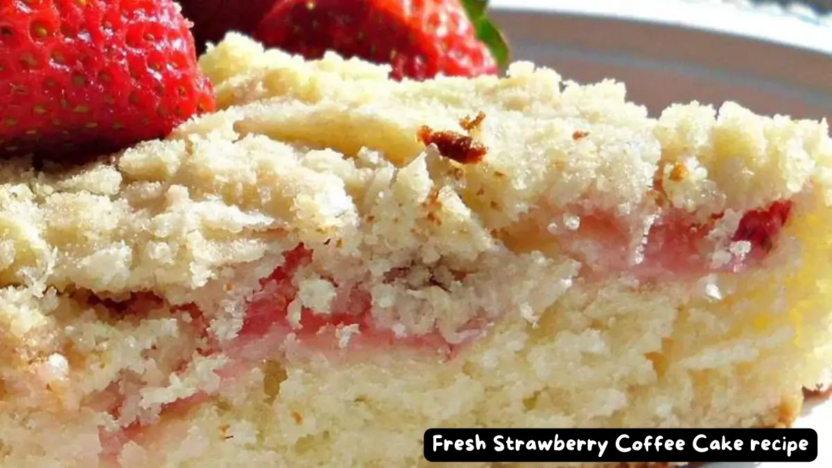 A slice of fresh strawberry coffee cake topped with whole strawberries, showcasing the cake's crumbly texture and vibrant fruit filling.