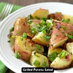 A bowl of grilled potato salad with bacon and fresh herbs.