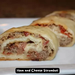 A freshly baked Ham and Cheese Stromboli sliced to reveal its delicious filling of ham, capacola, salami, pepperoni, mozzarella, and vegetables.