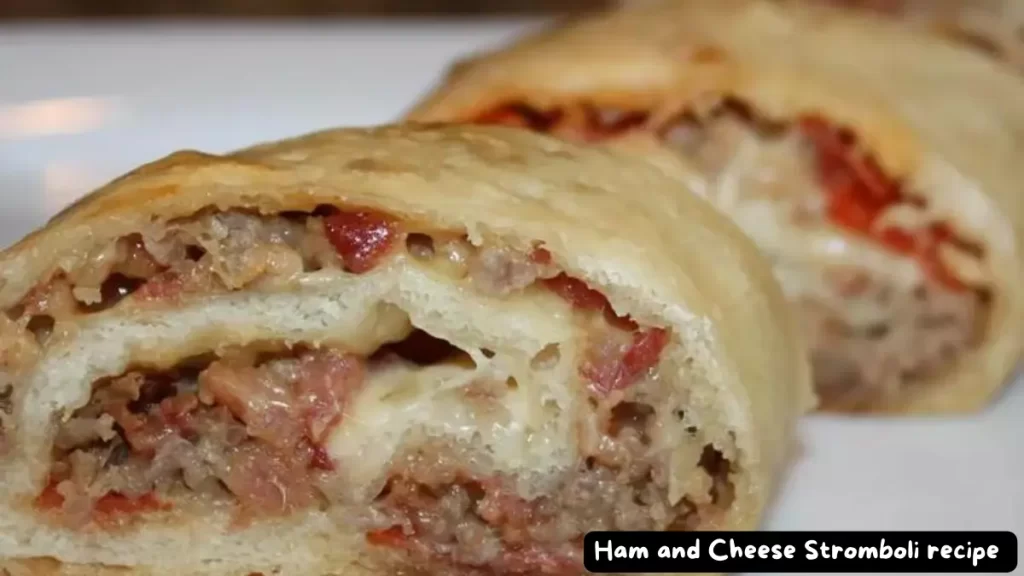 Close-up view of a sliced Ham and Cheese Stromboli showcasing the layers of ham, capacola, salami, pepperoni, mozzarella cheese, and vegetables wrapped in a golden-brown crust.