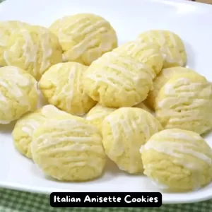 A plate of freshly baked Italian Anisette Cookies drizzled with anise icing.