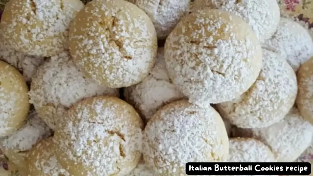 A close-up of Italian Butterball Cookies dusted with powdered sugar, showcasing their delicate and crumbly texture.