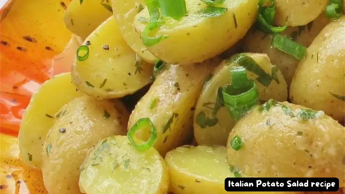 A close-up of Classic Italian Potato Salad garnished with fresh herbs and green onions.