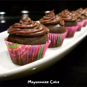 A slice of rich and moist chocolate mayonnaise cake on a white plate.