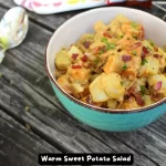 A bowl of warm sweet potato salad with crispy bacon and fresh herbs.