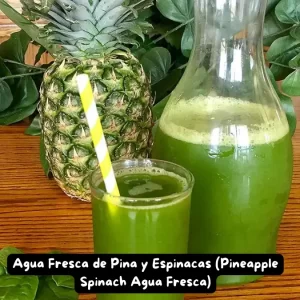 A glass of Pineapple Spinach Agua Fresca garnished with fresh pineapple and spinach leaves