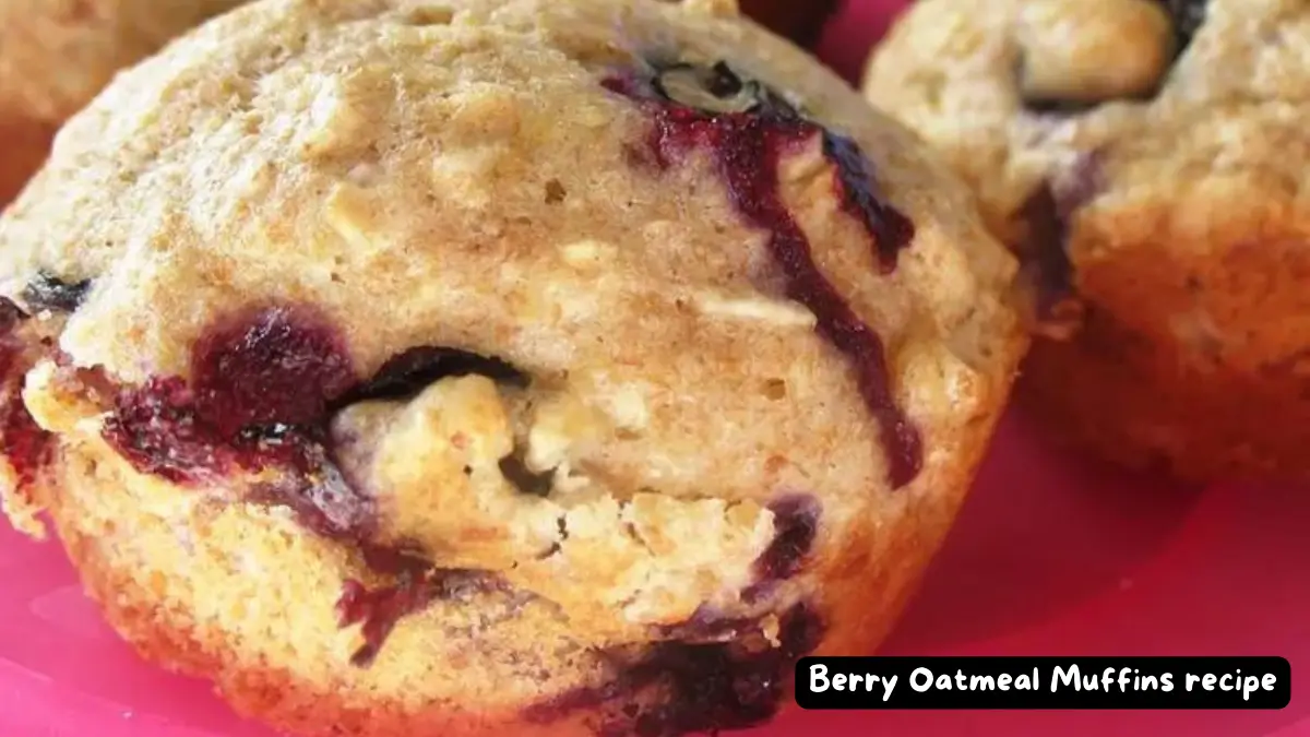 Freshly baked berry oatmeal muffins with a golden brown top, displayed close-up to show the delicious texture and berry pieces.