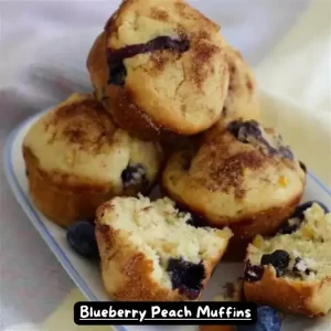 A tray of freshly baked blueberry peach muffins with a golden brown top.