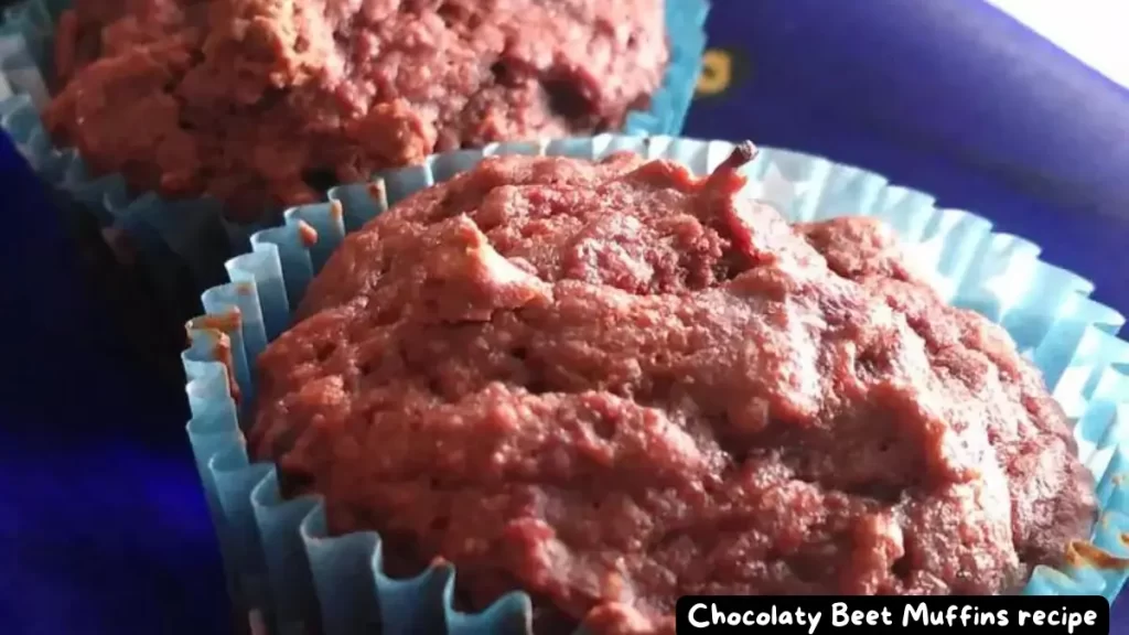 Close-up view of freshly baked chocolaty beet muffins in blue paper liners.