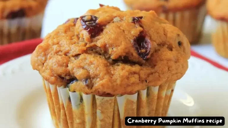 Close-up of a freshly baked Cranberry Pumpkin Muffin on a white plate.