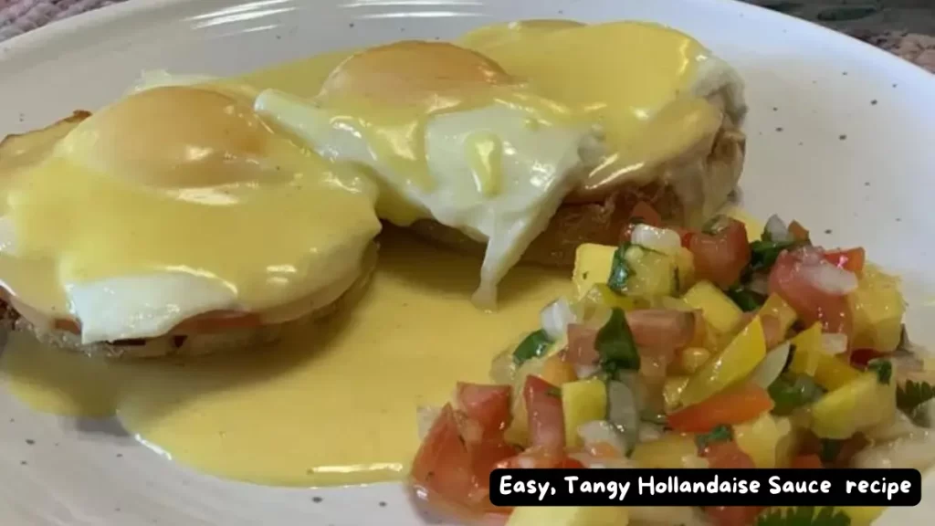 A plate of eggs Benedict topped with easy, tangy Hollandaise sauce, served with a side of fresh salsa.