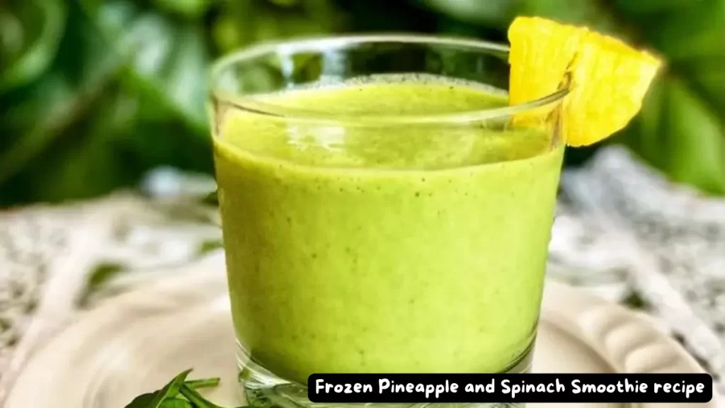 A close-up of a frozen pineapple and spinach smoothie in a glass, topped with a pineapple wedge, highlighting the creamy texture and vibrant green color.