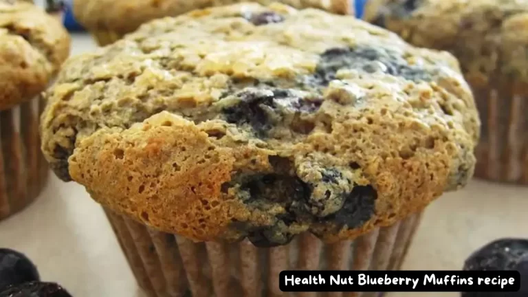 Close-up view of a Health Nut Blueberry Muffin with visible blueberries and a golden-brown top.