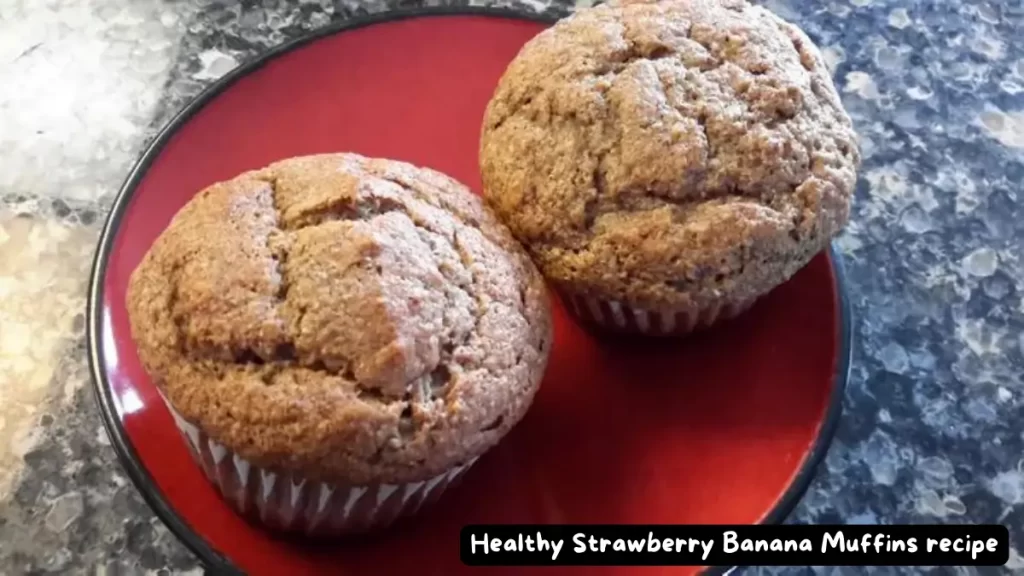 Three freshly baked strawberry banana muffins on a red plate, highlighting the golden-brown texture and fluffy appearance.