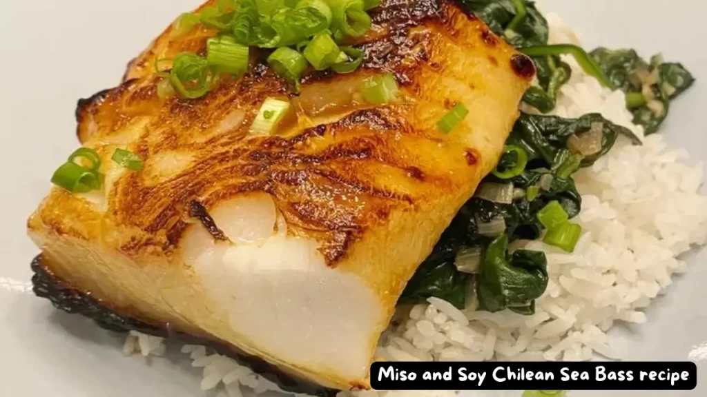 A deliciously broiled Miso and Soy Chilean Sea Bass fillet served with rice and sautéed greens, garnished with green onions.