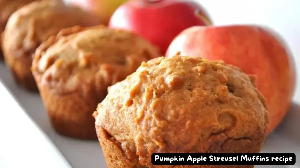 Close-up of freshly baked Pumpkin Apple Streusel Muffins with apples in the background.