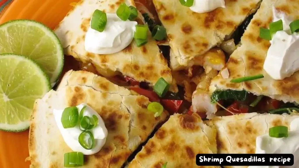 Golden-brown shrimp quesadillas topped with sour cream and green onions, served with lime slices.